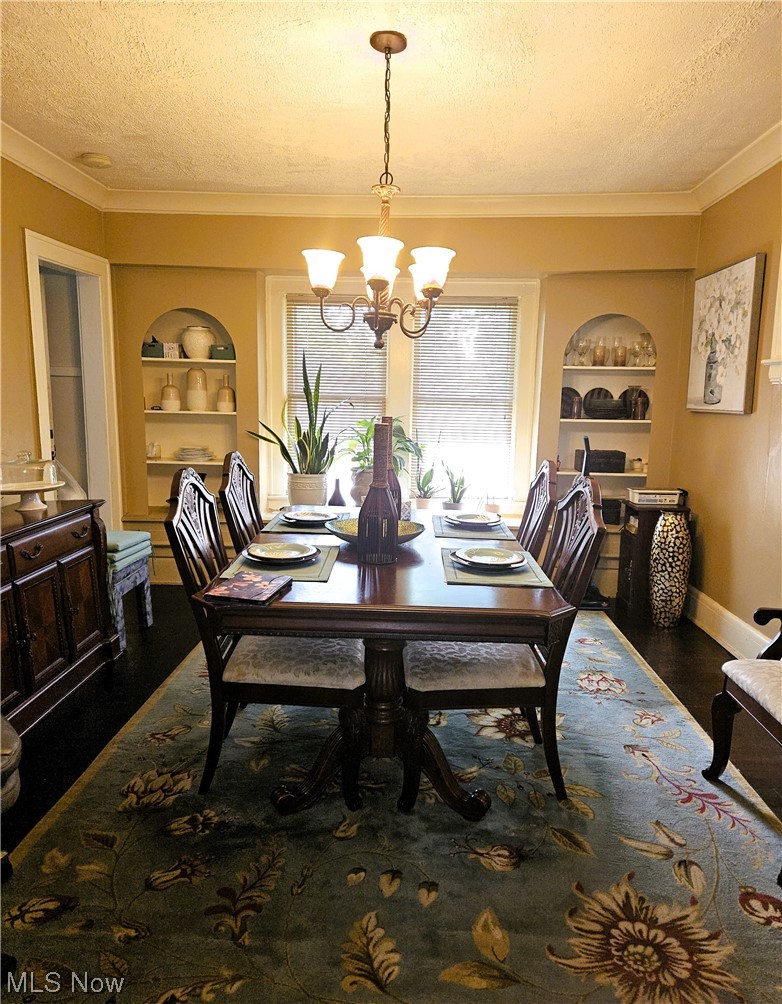 3364 Altamont Road Cleveland, OH 44118 - Photo 8 of 20 Dining area featuring built in shelves, chandelier, dark hardwood / wood-style floors, and a textured ceiling