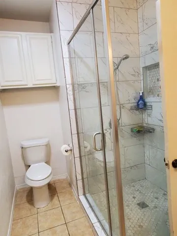 a bathroom with a toilet and a shower