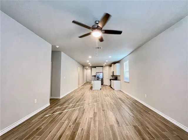 a view of a livingroom with a stove and wooden floor
