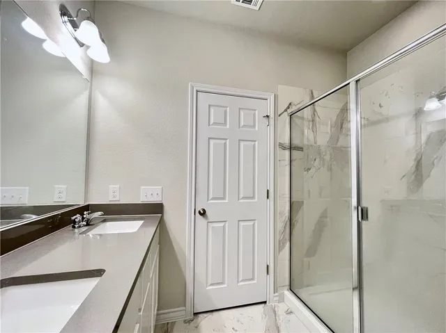 a bathroom with a sink a mirror and shower