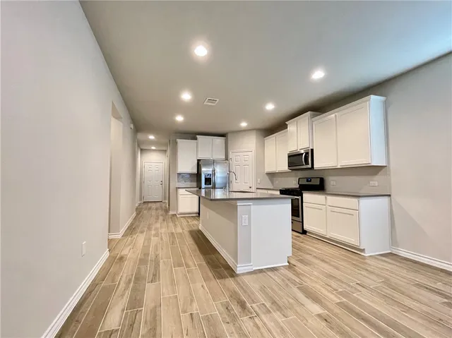 a kitchen with white cabinets sink and stainless steel appliances