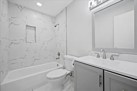 a bathroom with a sink toilet vanity and shower