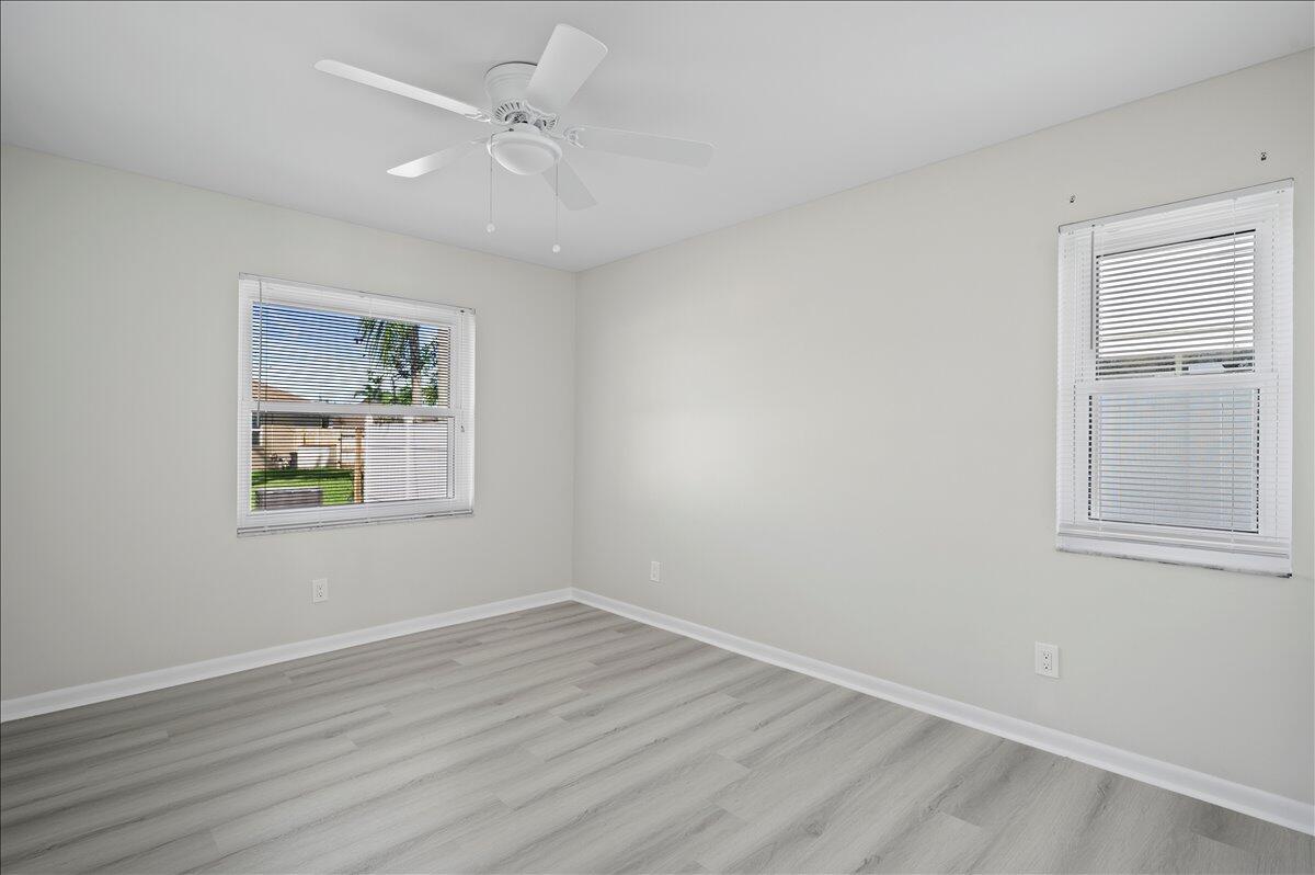 196 Raintree Trail Jupiter, FL 33458 - Photo 16 of 26 wooden floor in an empty room with a window