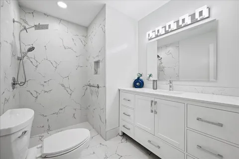 a bathroom with a sink a toilet and shower