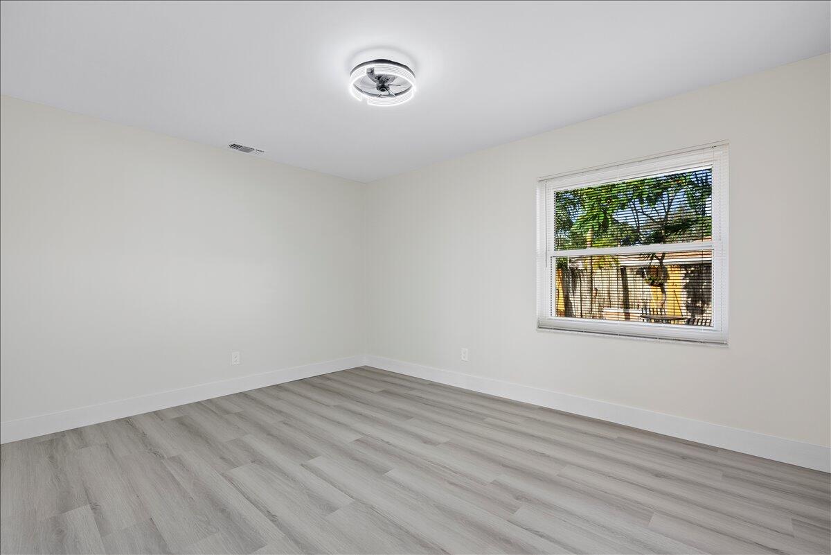 196 Raintree Trail Jupiter, FL 33458 - Photo 19 of 26 wooden floor in an empty room with a window