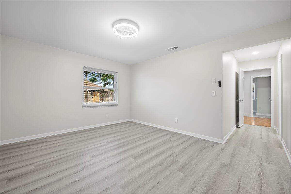 196 Raintree Trail Jupiter, FL 33458 - Photo 20 of 26 an empty room with wooden floor and windows