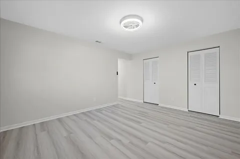 a view of an empty room with wooden floor