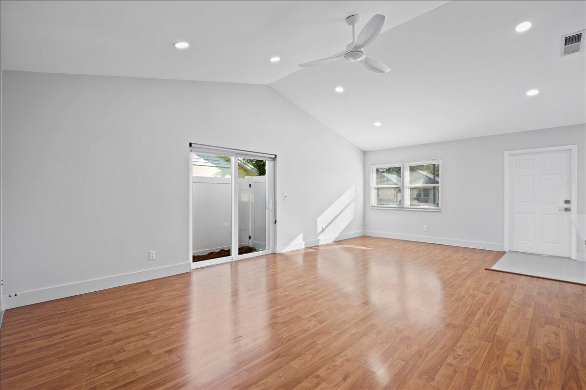 196 Raintree Trail Jupiter, FL 33458 - Photo 6 of 26 an empty room with wooden floor ceiling fan and windows