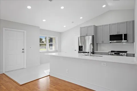 a kitchen with stainless steel appliances a refrigerator and a stove top oven