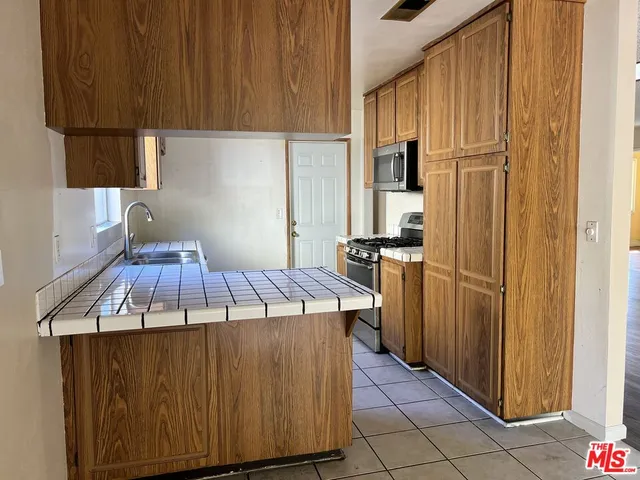 a kitchen with kitchen island a counter top space cabinets and stainless steel appliances