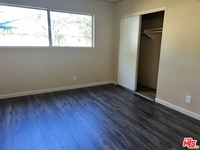 an empty room with wooden floor and a window