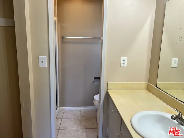 a bathroom with a granite countertop sink and toilet