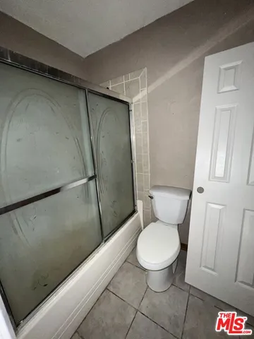 a white toilet sitting next to a shower