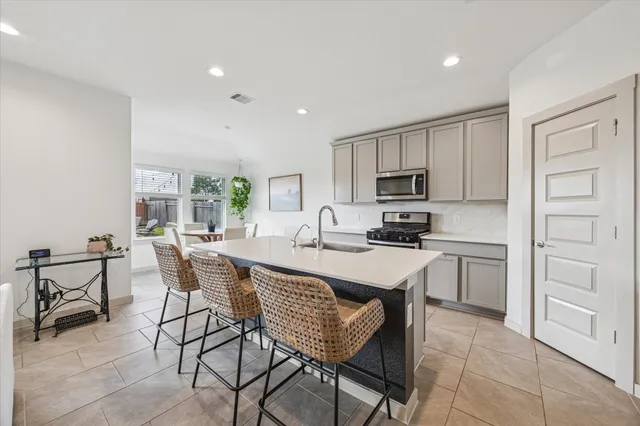 a kitchen with a table chairs microwave and cabinets