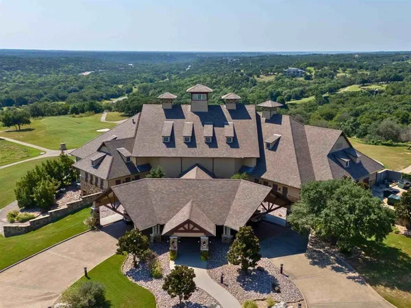 an aerial view of a house with a garden and lake view