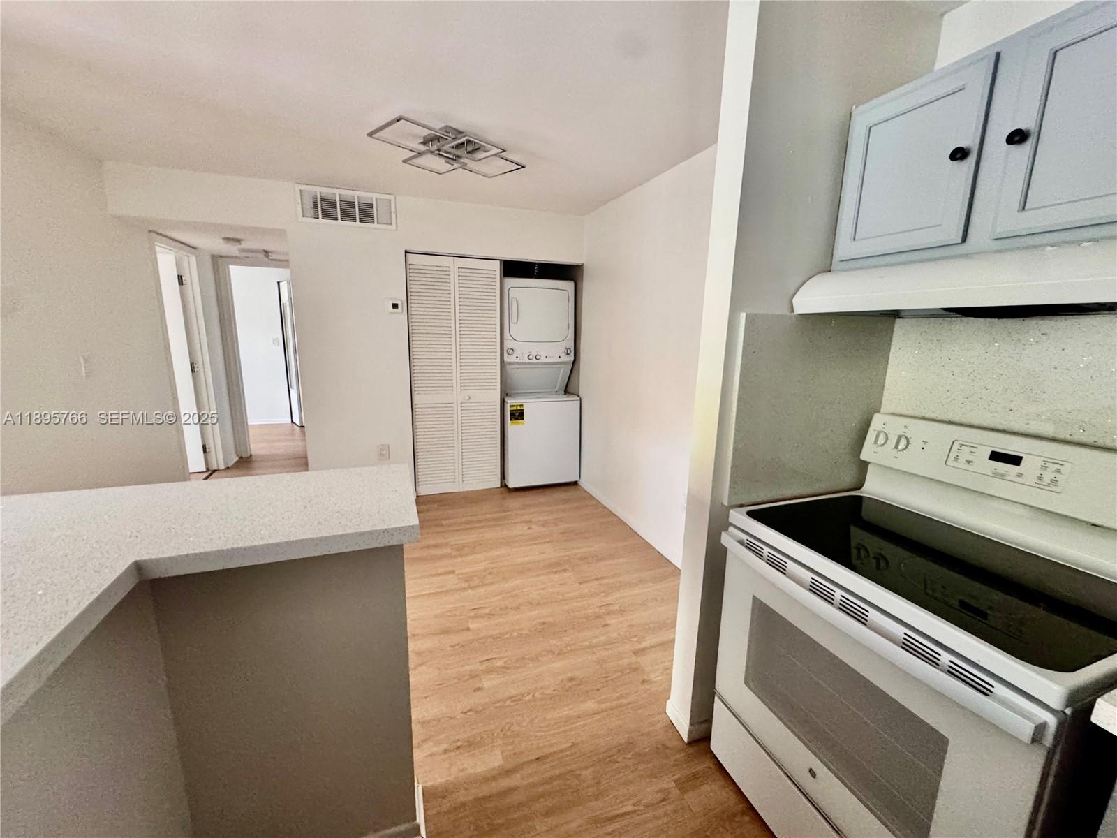 a view of a kitchen with stove and cabinets
