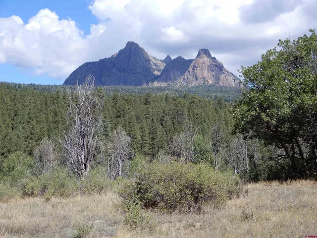 a view of dirt field with mountains in the background