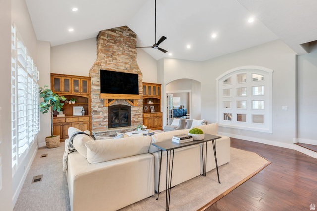 1355 West 1000 South Mapleton, UT 84664 - Photo 8 of 68 Vaulted ceiling living area featuring a stacked stone fireplace with wood mantel, built-in custom cabinetry, recessed lighting, and plantation shutters