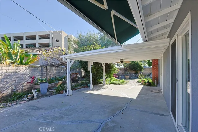 a view of a patio with table and chairs potted plants and floor to ceiling window and potted plants
