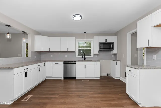 a kitchen with granite countertop a stove top oven sink and cabinets