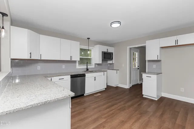 a kitchen with a sink cabinets and wooden floor