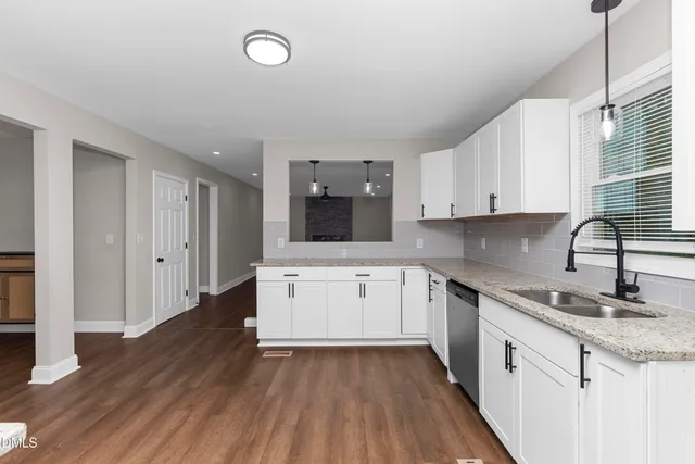 a kitchen with a sink window and cabinets