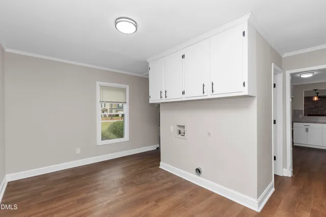 an empty room with wooden floor and a window