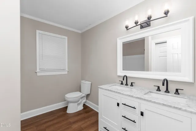 a bathroom with a granite countertop sink a toilet and a mirror