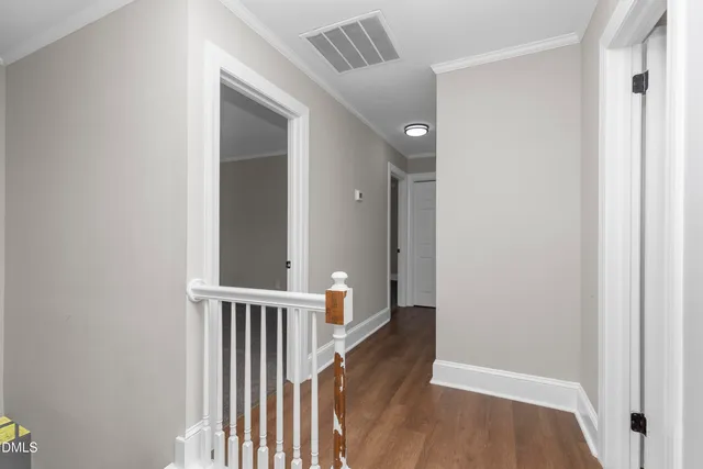 a view of a hallway with wooden floor and entryway