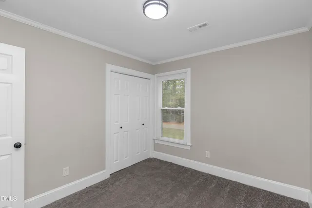 an empty room with windows and closet