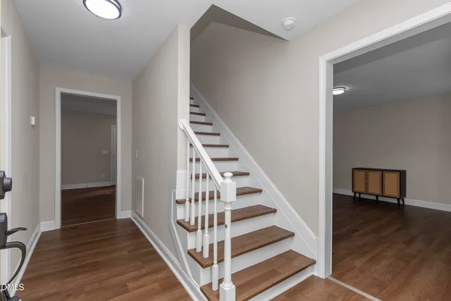 a view of a hallway with wooden floor and entryway