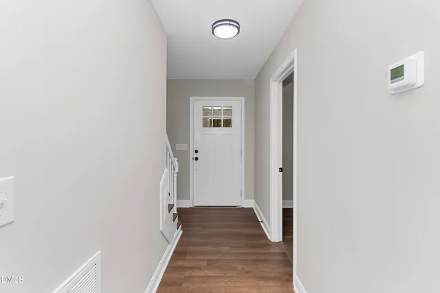 a view of a hallway with wooden floor and staircase