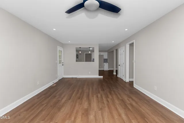 a view of empty room with wooden floor