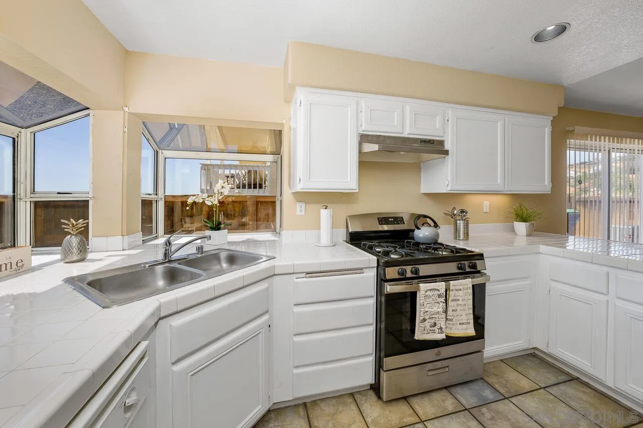 9765 Avenida Ricardo Spring Valley, CA 91977 - Photo 13 of 41 a kitchen with stainless steel appliances granite countertop a sink stove and cabinets