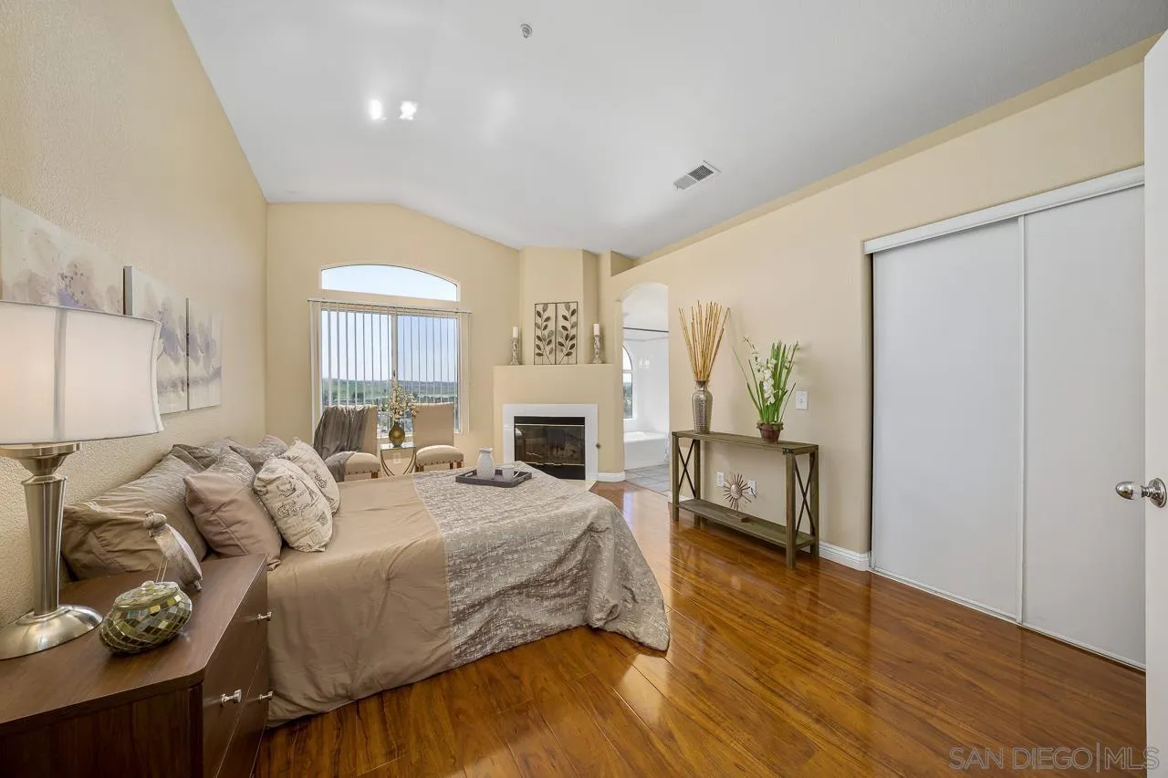 9765 Avenida Ricardo Spring Valley, CA 91977 - Photo 19 of 41 a spacious bedroom with a bed and a fireplace