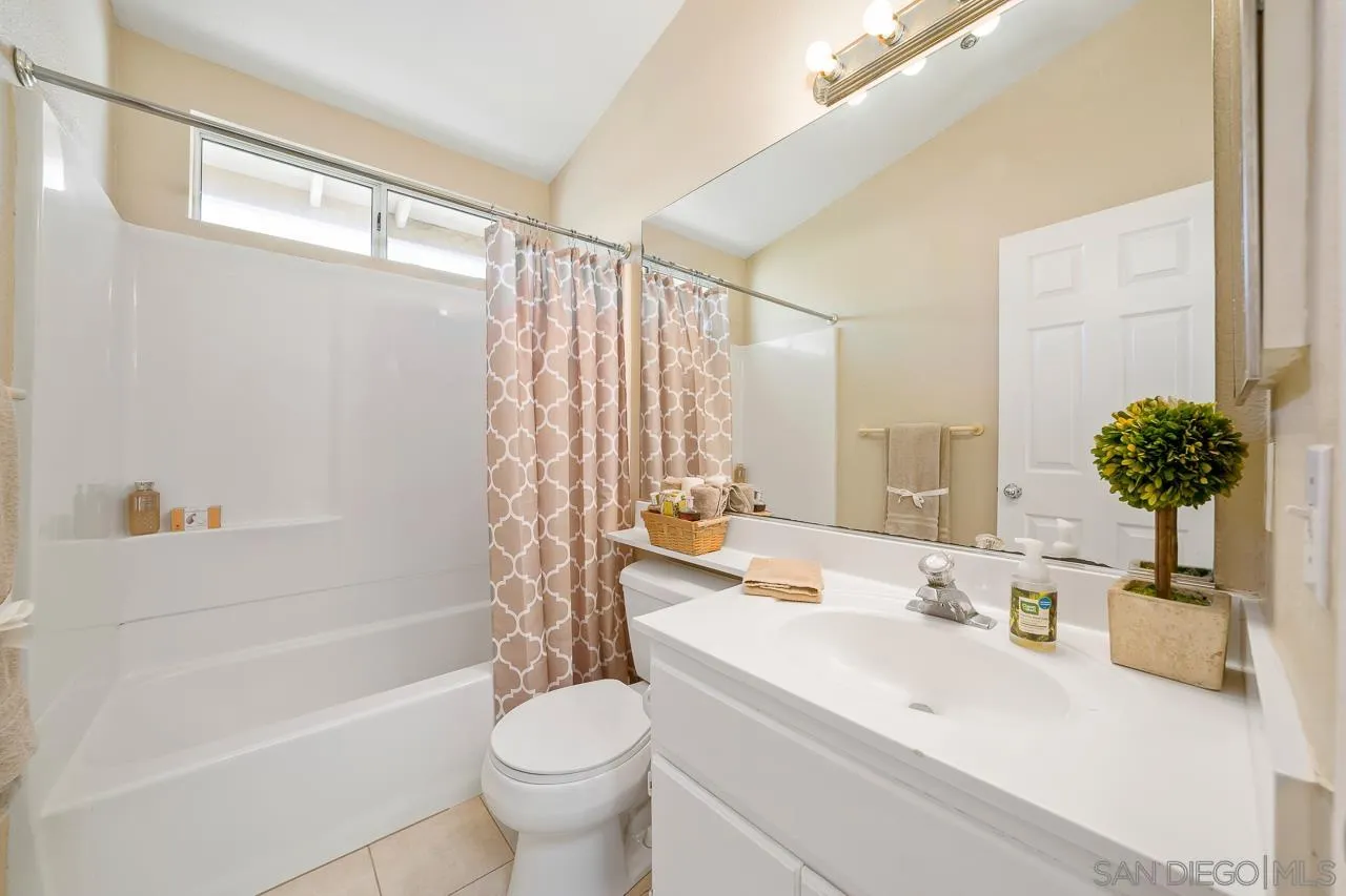 9765 Avenida Ricardo Spring Valley, CA 91977 - Photo 26 of 41 a bathroom with a sink a toilet a mirror a bathtub and shower