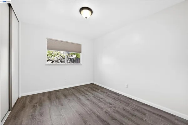 a view of a room with wooden floor and white walls