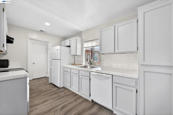 a kitchen with white cabinets and sink