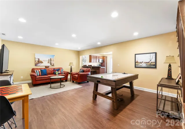 a living room with furniture and a dining table with wooden floor