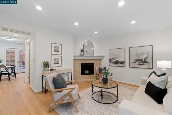 a kitchen with stainless steel appliances granite countertop a stove a sink dishwasher a refrigerator and white cabinets with wooden floor