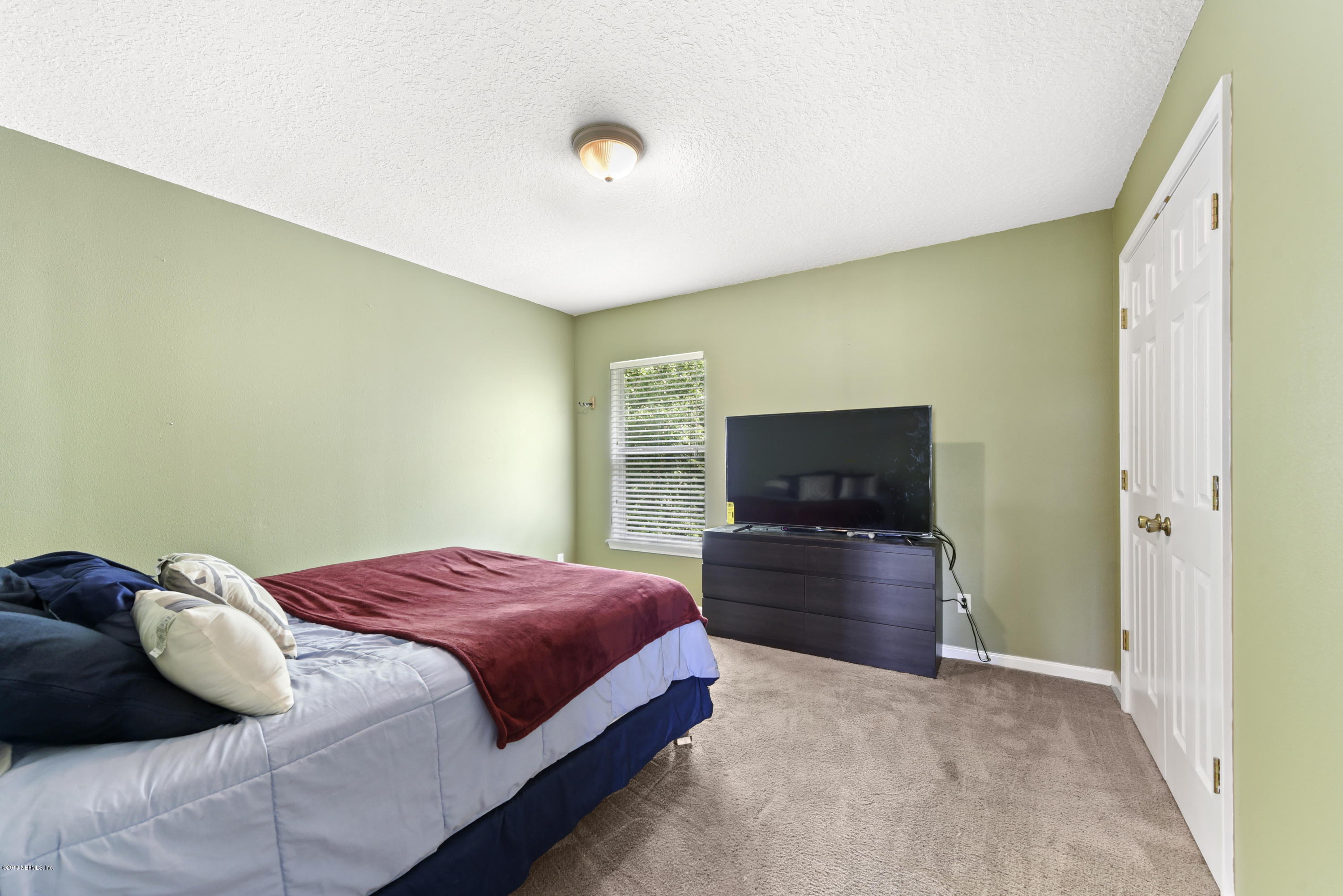 7254 Rampart Ridge Circle South Jacksonville, FL 32244 - Photo 17 of 28 a bedroom with a bed and flat screen tv