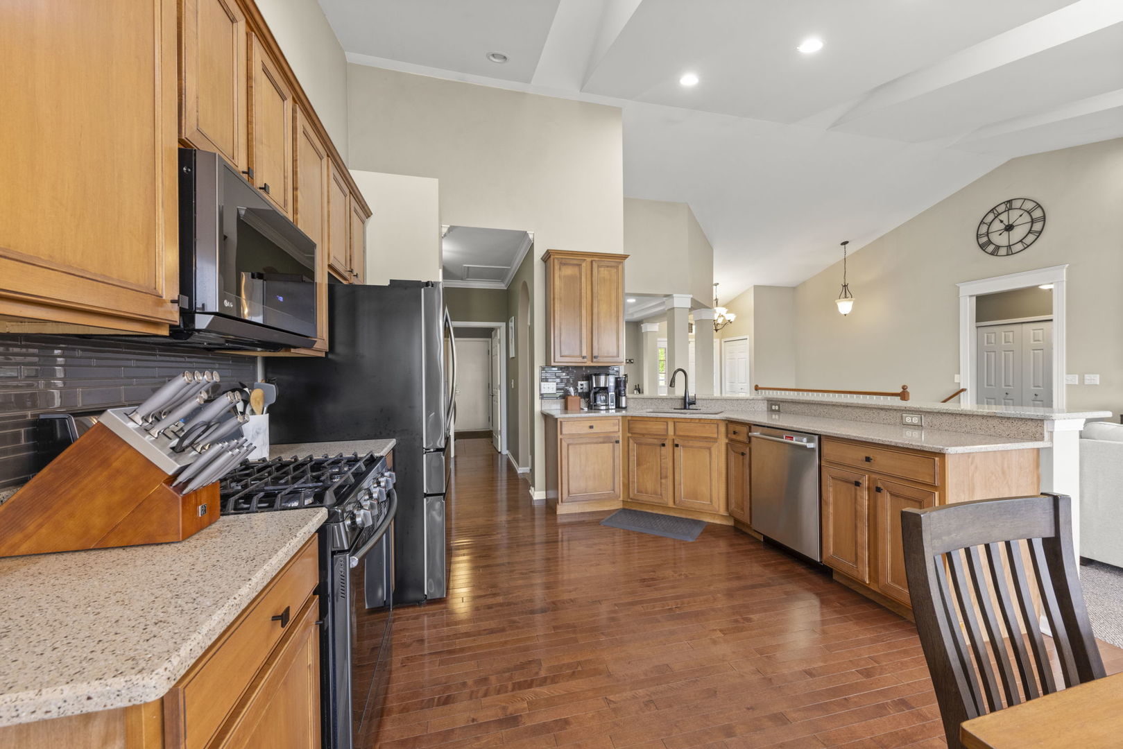 11625 Heritage Meadows Drive Plainfield, IL 60585 - Photo 12 of 40 a kitchen with stainless steel appliances granite countertop a stove top oven a sink dishwasher and a refrigerator with wooden floor
