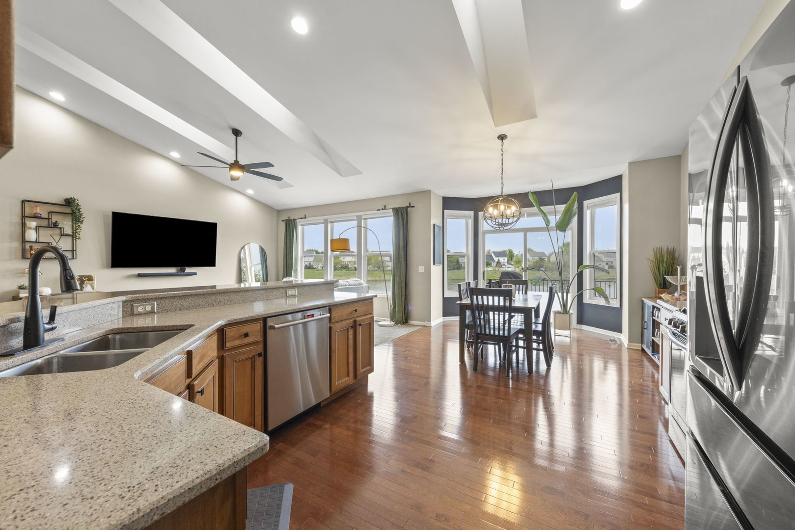 11625 Heritage Meadows Drive Plainfield, IL 60585 - Photo 13 of 40 a kitchen with stainless steel appliances granite countertop a stove top oven a sink a dining table and chairs with wooden floor