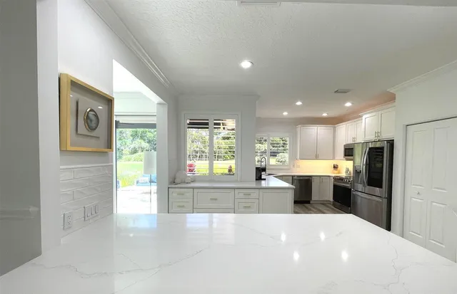 a kitchen with white cabinets and stainless steel appliances