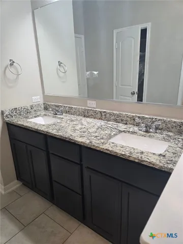 a bathroom with a granite countertop sink and a mirror