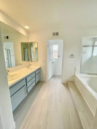 a bathroom with a tub sink and mirror