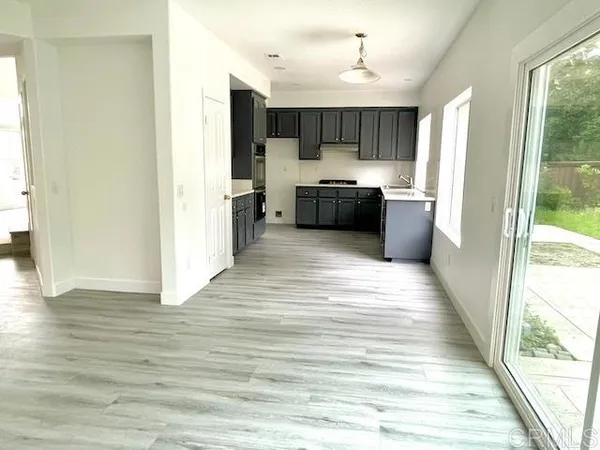 a kitchen with stainless steel appliances kitchen island granite countertop a refrigerator and a sink