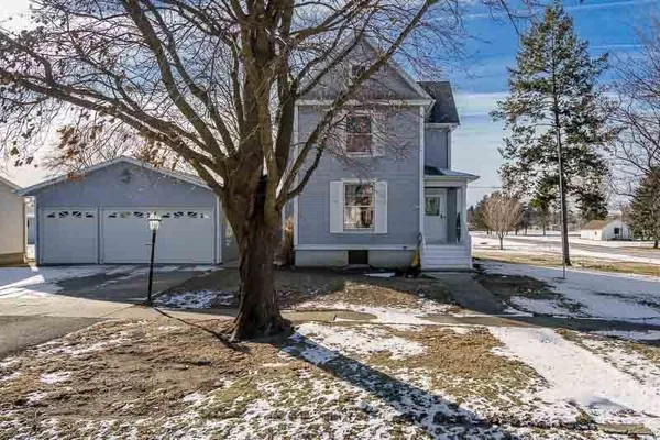 a tree in front of a white house