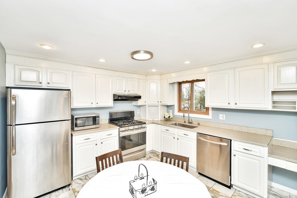 15 Old Farm Road Randolph, MA 02368 - Photo 3 of 22 a kitchen with white cabinets stainless steel appliances and refrigerator
