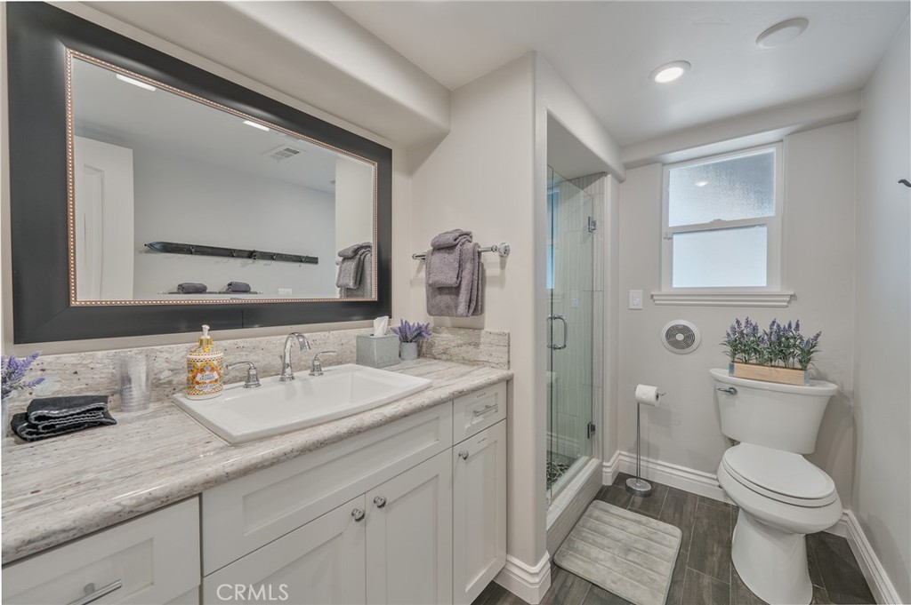 27550 North Bay Road Lake Arrowhead, CA 92352 - Photo 38 of 53 a bathroom with a granite countertop toilet sink and mirror